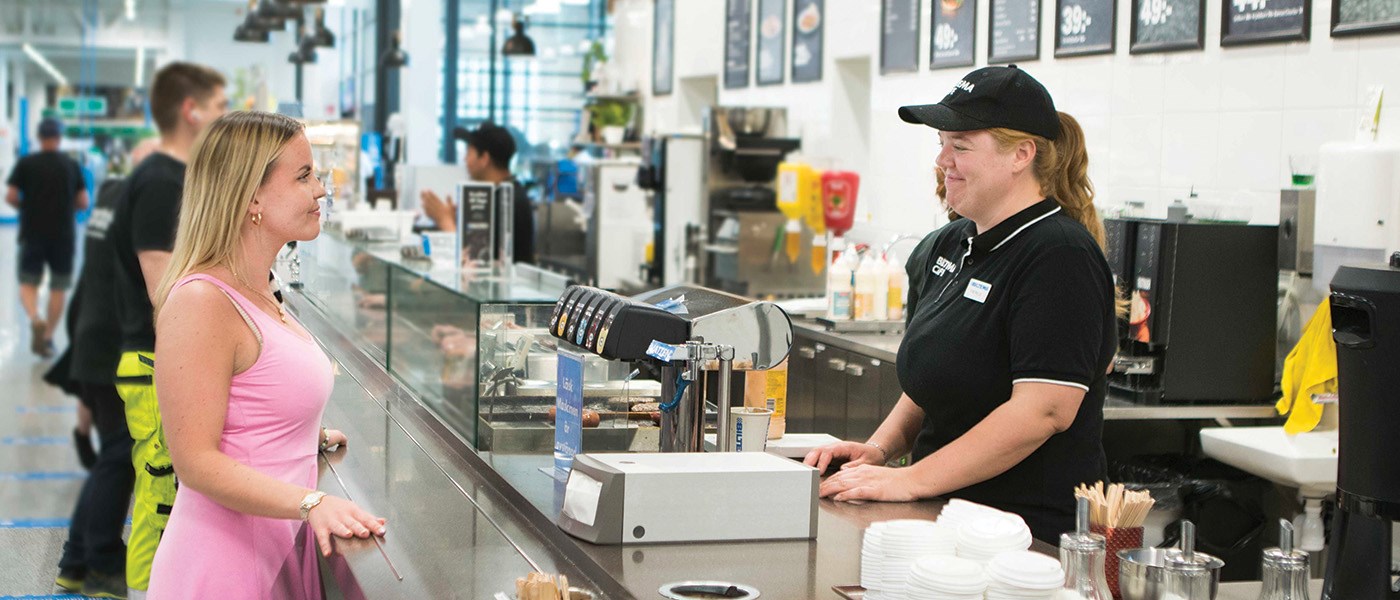 Kuvassa Biltema Cafen myyjä palvelee asiakasta